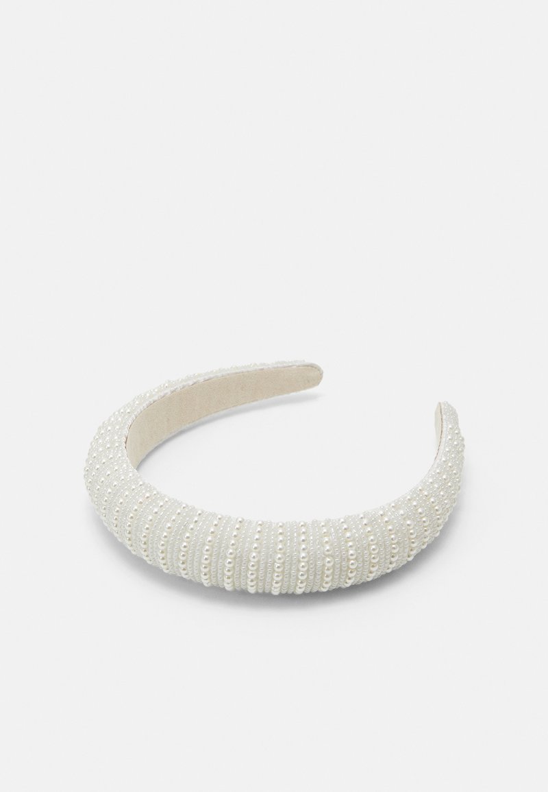 Fehér szövet hajpánt, melyet apró, sima gyöngyök díszítenek, texturált, bordázott mintázattal a további részletekért.