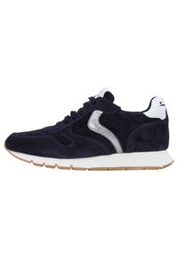 Marineblauwe suède sneaker met witte en zilveren accenten, textuur op het oppervlak, rubberen zool en klassiek vetersluiting ontwerp. Geribbelde buitenzool voor grip.
