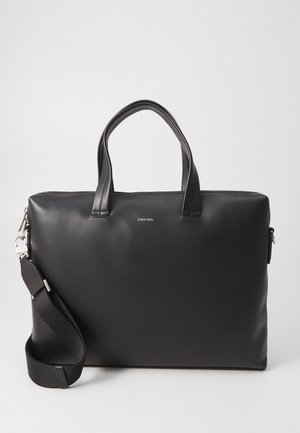 Zwarte leren laptoptas met twee bovenhandvaten, een afneembare schouderriem en een ritssluiting. Heeft een subtiele logo op de voorkant.