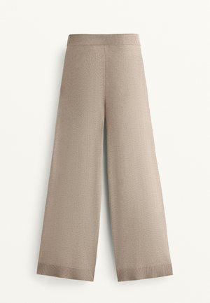 Beigeweite Beinhosen mit einem gerippten Bund, die eine weiche Textur und einen geraden Schnitt aufweisen. Einfache Saumdetails am unteren Ende.