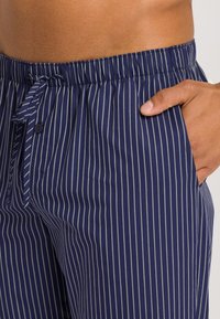 Marine gestreepte loungebroek met een elastische tailleband, trekkoord en knoopdetail; voorzien van zijzakken en een soepele textuur.