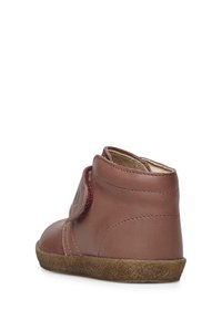 Stivale alla caviglia in pelle marrone con tacco testurizzato, punta tonda e cinturino in velcro. Rivestimento interno morbido e suola in gomma marrone flessibile.