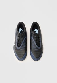 Must mustad ja sinised Nike jalgpalliketsid nagu nöörid, vaadatuna ülalt valgel taustal.