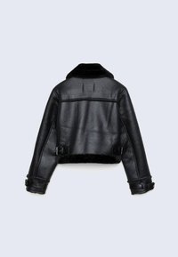 Veste d'aviation en cuir noir avec col en vison, sangles à boucles aux poignets et à la taille, vue de dos sur un fond clair.