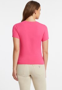 Guess Jeans CON SCOLLO A V AMERICAN TRADITION  - T-shirt basic - fucsia