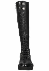 Botas de piel negras hasta la rodilla con cordones en la parte delantera, acentos de hardware plateado y suela gruesa. Textura suave y puntera reforzada.