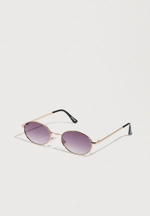 Round sunglasses with gradient purple lenses, gold metal frame, and thin black plastic temple arms. Minimalist design with no visible logos.