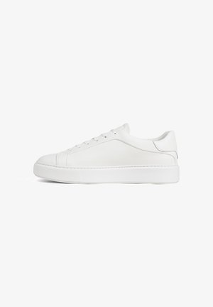 Witte lederen sneaker met lage schoenrand, veters aan de voorkant en dikke rubberen zool, zijaanzicht op een witte achtergrond.