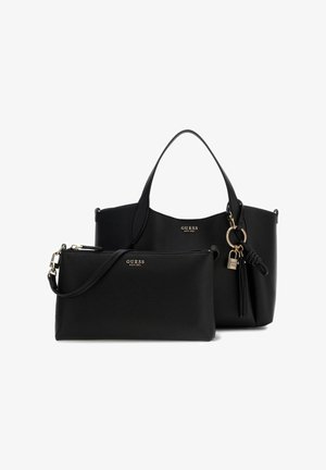 Sac à main noir Guess avec deux anses et pochette noire assortie avec bandoulière, tous deux avec logos dorés et un pompon décoratif et une serrure.