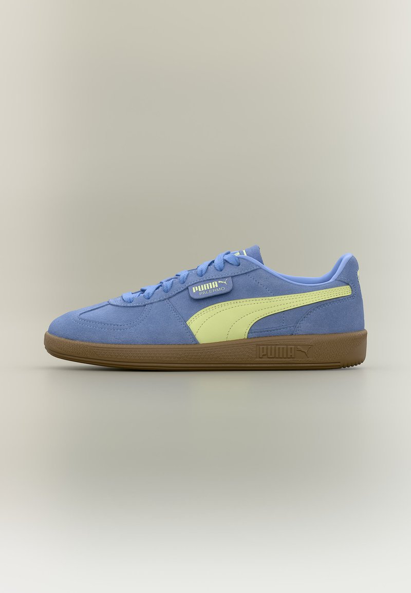 Μπλε sneaker Puma Palermo με ανοιχτό κίτρινη ρίγα, σόλα από καουτσούκ και κορδόνια σε ουδέτερο φόντο προς τα αριστερά.