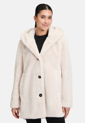Manteau en fausse fourrure beige clair, avec capuche, fermeture à boutons et poches latérales. Texture lisse avec un aspect doux et moelleux.