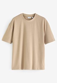 Beige tričkový top s krátkým rukávem vyrobený z měkké bavlněné látky. Má kulatý výstřih a volný střih s hladkou, rovnoměrnou texturou.