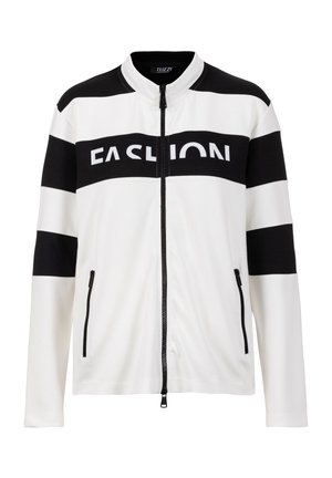 Witte jas met ritssluiting en zwarte horizontale strepen op de mouwen en borst, met het woord "FASHION" in dikke letters op de borstband.