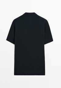 Polo shirt a maglia blu navy con maniche corte, caratterizzato da un motivo testurizzato, colletto a costine e orlo dritto. Tessuto morbido con una moderata elasticità.