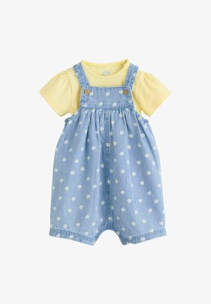 Világos farmer kantáros ruha sárga rövid ujjú inggel. A kantáros ruhán fehér margaréta mintás és fa gombok; puha pamut anyagból.