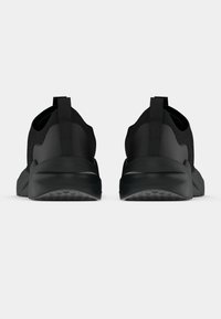 Zapatos deportivos negros con una parte superior de tejido texturizado, un talón acolchado y una suela flexible. Cuenta con una lengüeta para facilitar el uso.