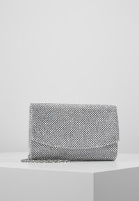 Clutch bag metallica argento con disegno a rete, chiusura a pattina e tracolla removibile. Superficie testurizzata con piccoli dettagli riflettenti.