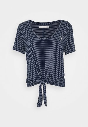 Tummansininen lyhythihainen T-paita, jossa valkoiset vaakaraitoja, syvä V-kaula-aukko ja edessä solmimisdetaili. Valmistettu pehmeästä kankaasta.