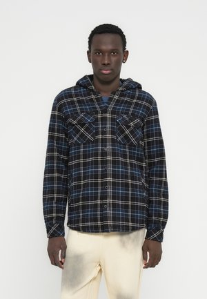 Blauw-zwart geruit flanellen shirt met capuchon, voorzien van twee borstzakken met knoopsluiting en een losse pasvorm. Gladde textuur en zichtbare stiksels.