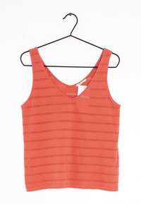 Top de tirantes color coral con escote en V, diseño sin mangas y patrones de cortes horizontales. La tela parece ligera y texturizada. Se cuelga de un gancho negro.