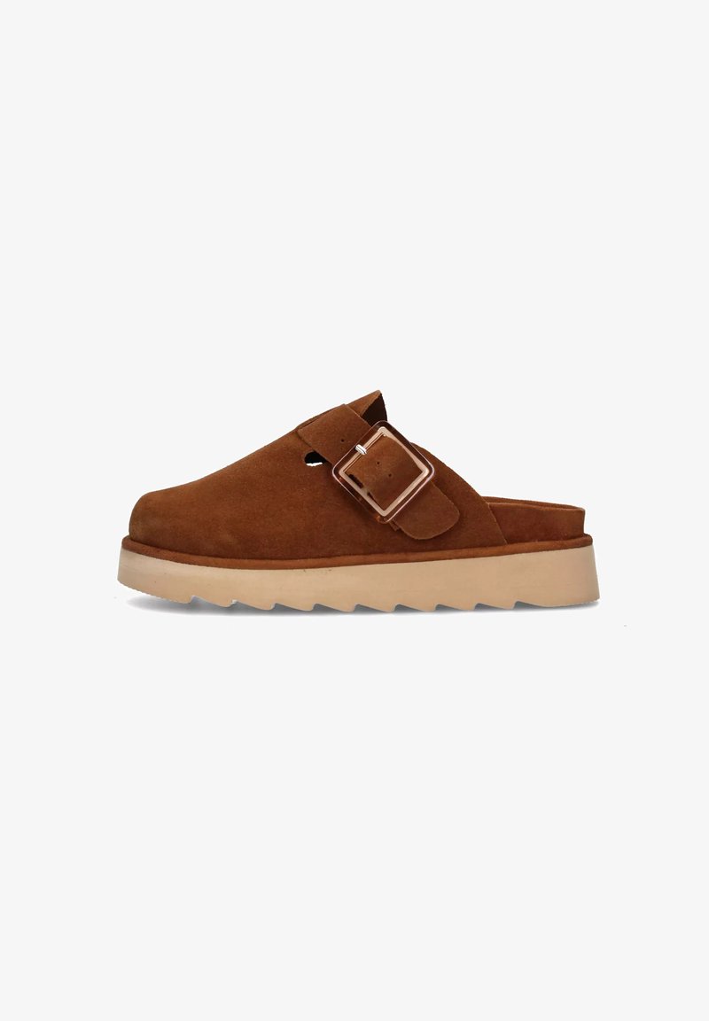 Sabot en suède marron avec un dos ouvert, sangle à boucle réglable et semelle en caoutchouc beige dotée d'un bord denté pour une meilleure adhérence.
