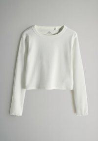 Biała krótka bluzka z długimi rękawami, wykonana z prążkowanej tkaniny. Posiada okrągły dekolt oraz lekko rozszerzane mankiety. Brak widocznych grafik lub wzorów.