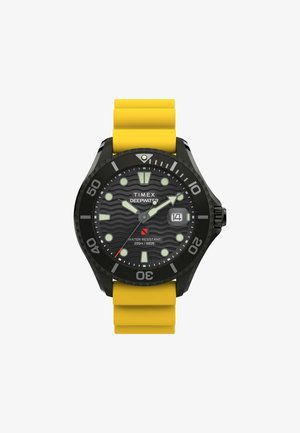 Zegarek Timex Deepwater z czarną kopertą, żółtym silikonowym paskiem, czarną tarczą z wzorem fal, świecącymi znacznikami oraz wyświetlaczem daty. Wodoodporny do 200 m.