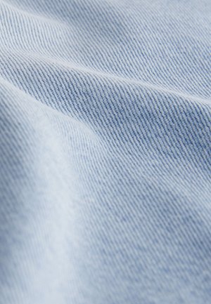 Material de denim albastru deschis cu o țesătură subtilă în diagonală, evidențiind linii fine diagonale și o textură netedă, ușor drapat și pliat.