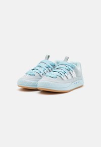 Light blue and gray sneakers with textured fabric, featuring striped laces, white accents, a geometric patterned sole, and a pull tab.