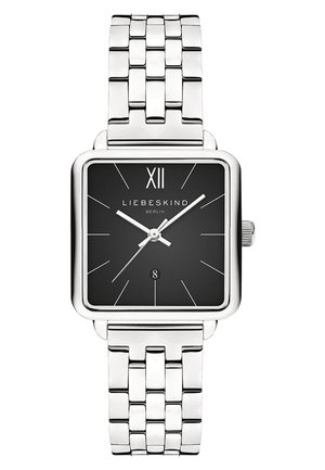 Montre à cadran carré noir avec un bracelet en acier inoxydable argenté. Elle comprend des chiffres romains, des aiguilles fines et un affichage de la date à 6 heures.