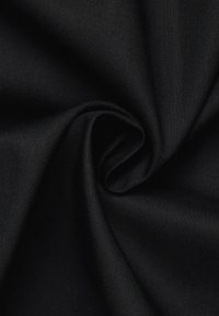 Tessuto nero con una texture liscia, leggermente elasticizzato, caratterizzato da un motivo a trama semplice e una leggera lucentezza, disposto in un arrangiamento sciolto a spirale.
