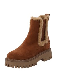 Botas de tobillo de ante marrón con un borde de piel de pelo y paneles laterales elásticos. Suela de goma gruesa y estriada para tracción y comodidad.