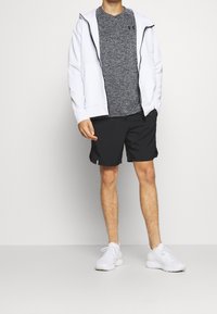 Herroutfit med en vit hoodie, grå texturerad T-shirt, svarta shorts och vita sportskor. Enkel design och neutrala färger.