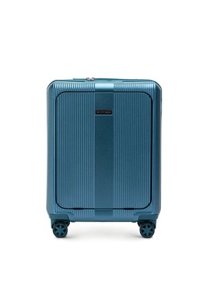 Hard-shell suitcase in metallic teal finish, featuring vertical ribbed pattern, smooth surface, and four spinner wheels for mobility.