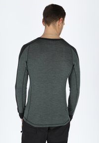 Long-sleeve shirt in dark gray with a textured finish, featuring black accents on the shoulders and cuffs, and a fitted design.