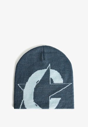 Beanie lavorato a maglia di colore blu scuro con un grande logo bianco che presenta una lettera "C" stilizzata e un motivo a stelle. Texture morbida, forma aderente.