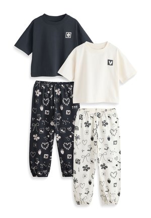 Dva sety voľnočasových pyžám: jeden s čiernym crop topom a zodpovedajúcimi čiernymi nohavicami s bielymi kvetinovými a srdiečkovými vzormi, druhý s bielym crop topom a zodpovedajúcimi bielymi nohavicami s potlačou.