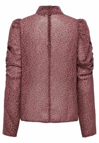 Bordeaux bluse med transparent stof og blomsterdesign, lange ærmer med samlet detalje og knaplukning bagpå.