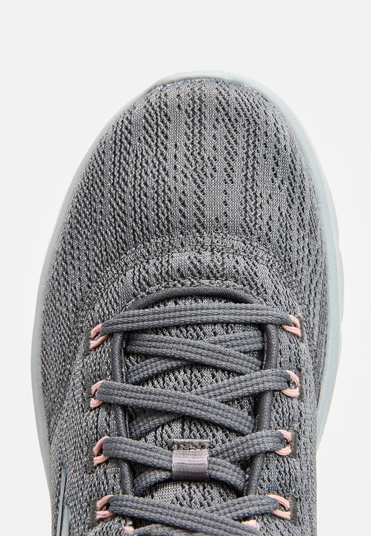 Grau gestrickter Athletikschuh mit einer strukturierten Oberseite, rosa Schnürsenkelakzenten und einer flexiblen durchsichtigen Sohle. Verfügt über ein reguläres Schnürdesign.