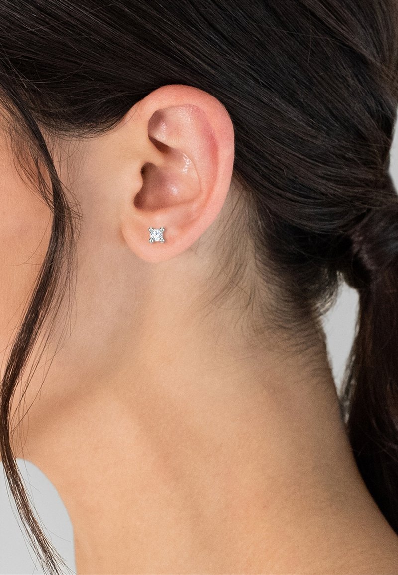 Los pendientes de botón de plata de ley presentan un diseño cuadrado con cuatro pequeñas gemas claras en cada esquina, mostrando un acabado brillante.