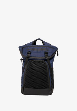 Sac à dos navy à rabat avec panneau en maille noire, straps réglables et détail de marque. Il dispose d'une poche zippée et de poignées robustes.
