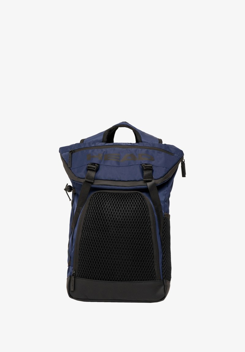 Sac à dos navy à rabat avec panneau en maille noire, straps réglables et détail de marque. Il dispose d'une poche zippée et de poignées robustes.