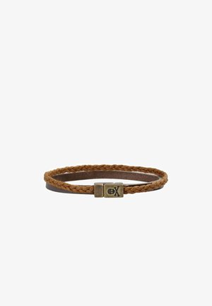 Pulsera de cuero trenzado marrón con un cierre de bronce que presenta un emblema de calavera y huesos cruzados sobre un fondo blanco.