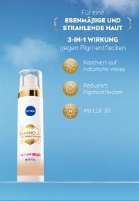 NIVEA Luminous 630 CC fluid in white packaging with gold accents, features a pump dispenser and claims to reduce pigmentation with SPF 30.