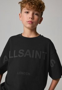 Must musta T-särk lõdva lõikega, millel on suured tõstetud teksti "ALLSAINTS" ja "LONDON" peene mati viimistlusega. Ümar kaelus, lühikesed varrukad.