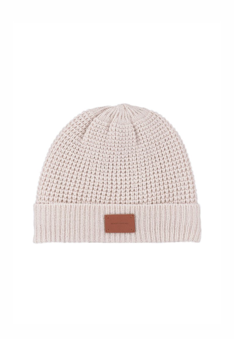 Gebreide beanie in lichtbeige met een gestructureerd weefpatroon, omgevouwen manchet en een rechthoekige leren patch met reliëfbranding aan de voorkant.