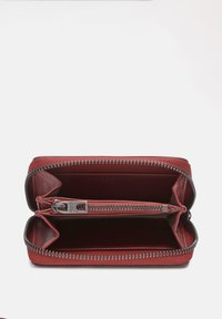 Rood ritsportemonnee met een textuurafwerking, voorzien van twee compartimenten en een centraal ritsvak. Zilveren ritsbeslag langs de randen.