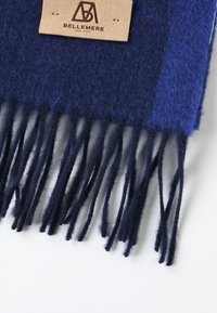 Sciarpa di lana blu navy con bordi frangiati, dotata di un'etichetta in pelle con la scritta "BELLEMERE NEW YORK" in rilievo marrone. Finitura morbida e tessurizzata.