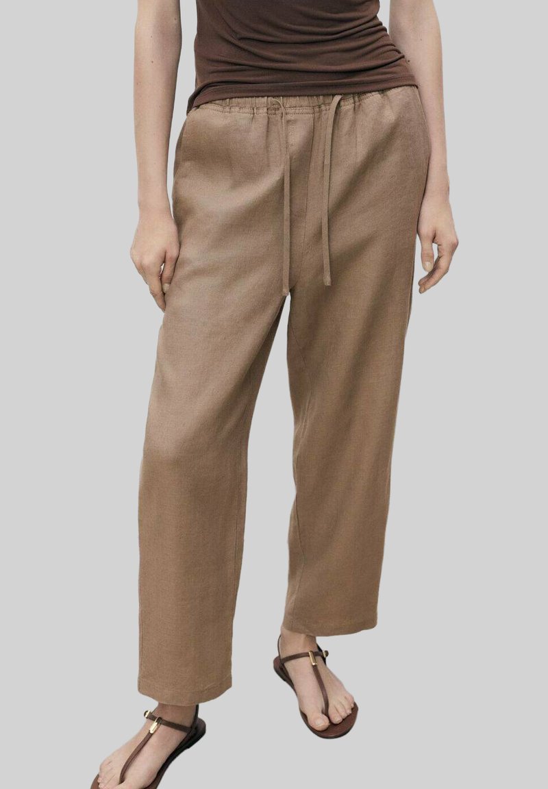 Pantaloni in lino marrone chiaro con vestibilità rilassata, dotati di una cintura elastica e cordino, texture liscia e design a gamba ampia.