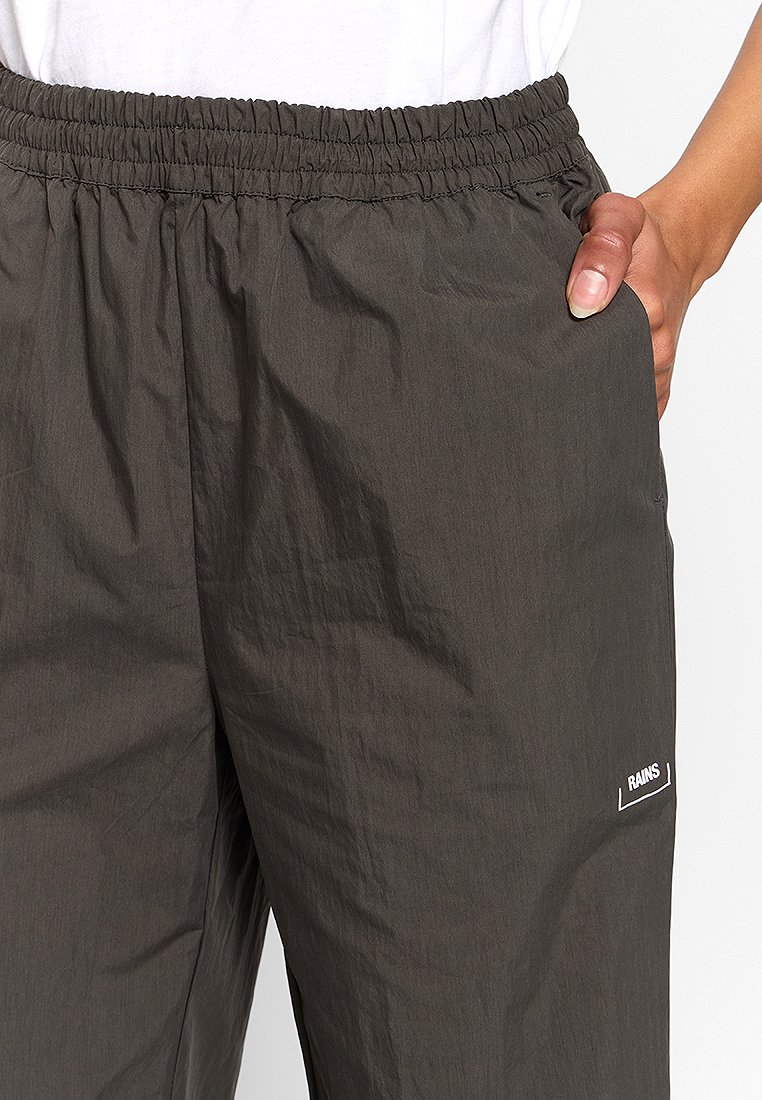 Hose mit elastischem Bund in Dunkelgrün, aus leichtem Material mit glatter Textur. Verfügt über seitliche Taschen und ein weißes Logo-Detail.